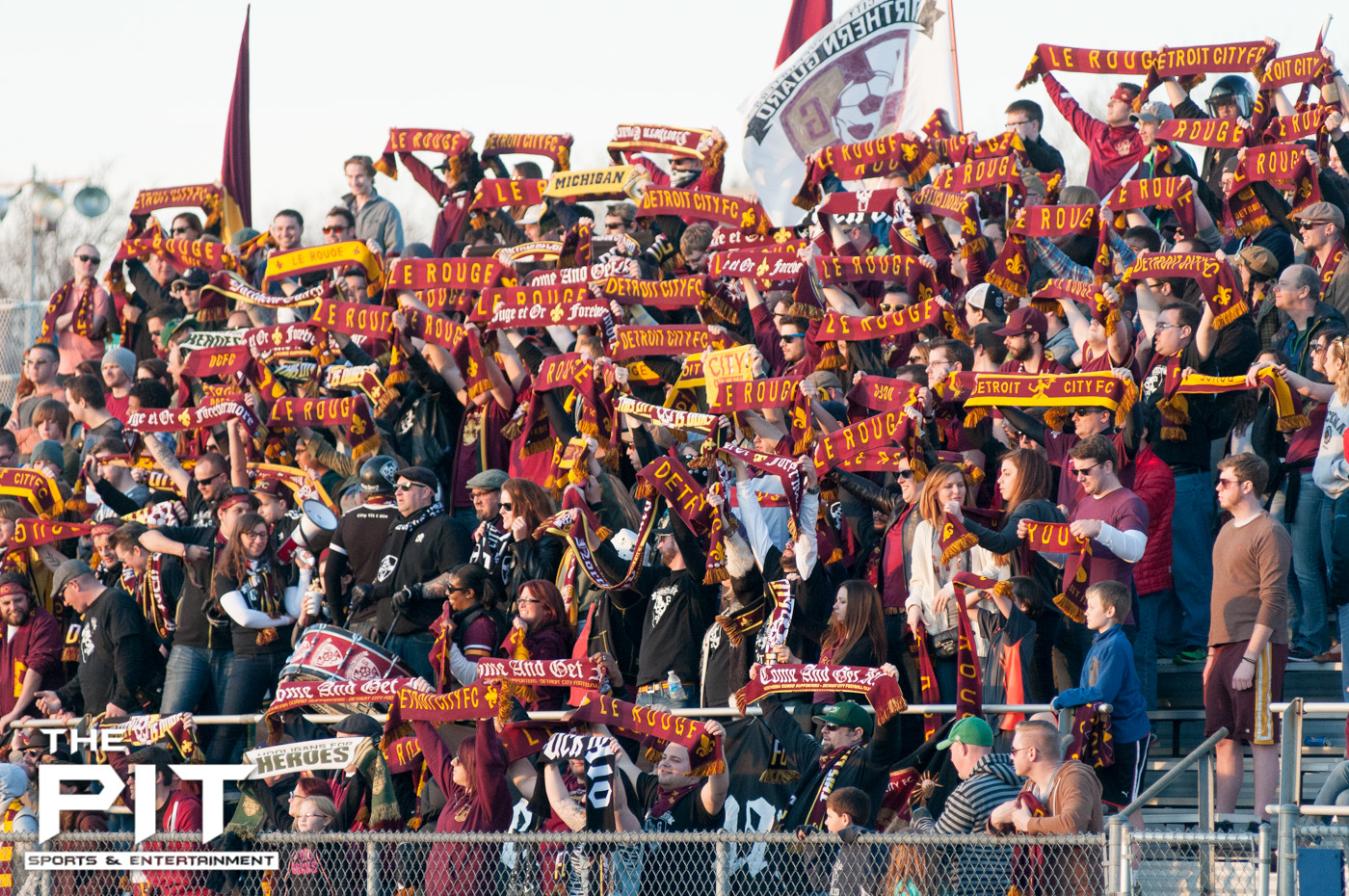 A packed Detroit City FC crowd show off their "Le Rouge" and "Detroit City FC" scarfs to the opposing teams stands at a scrimmage match against Saginaw Valley on April 19, 2014 at Hurley Field. Brian Quintos / The Pit: SE