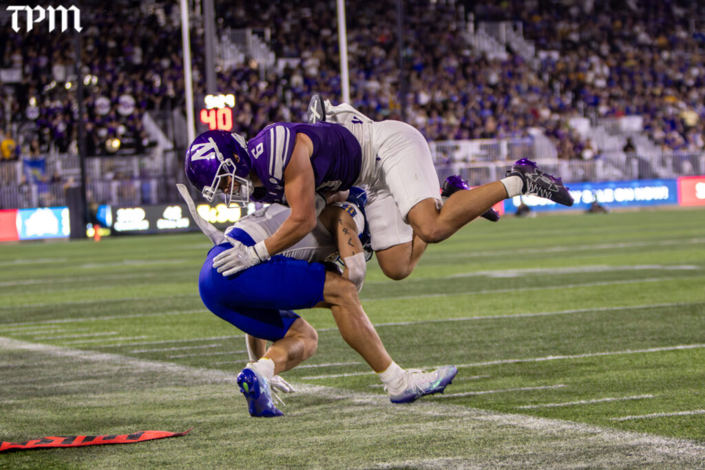 Northwestern defensive back Robert Fitzgerald (6) tackles a South Dakota State receiver along the sideline Saturday in Evanston. (Damien Dennis/TPM